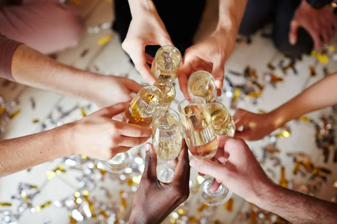 Hands toasting with sparkling wine during an event or special evening.
